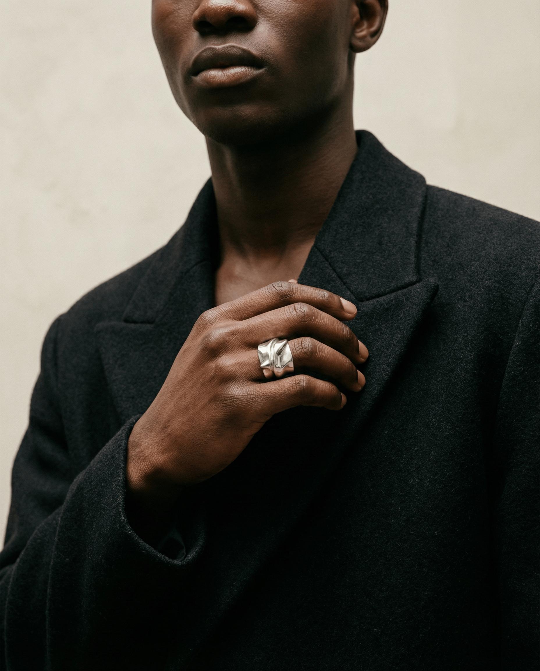 Person wearing a dark coat with a neutral background
